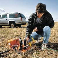geophysicist setting up equipment for experiment in field